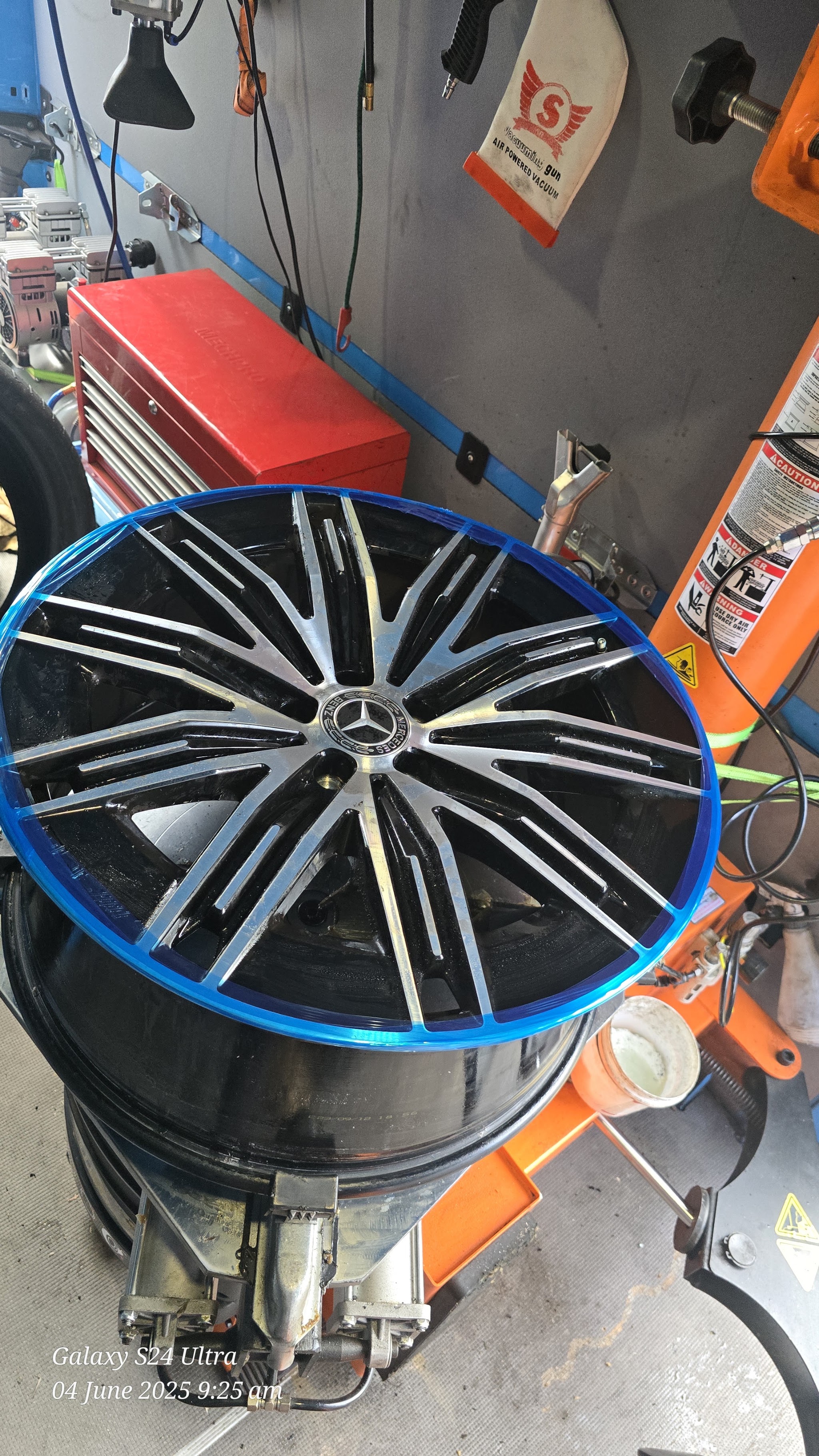 A Mercedes wheel having a new tyre mounted on the fitting machine