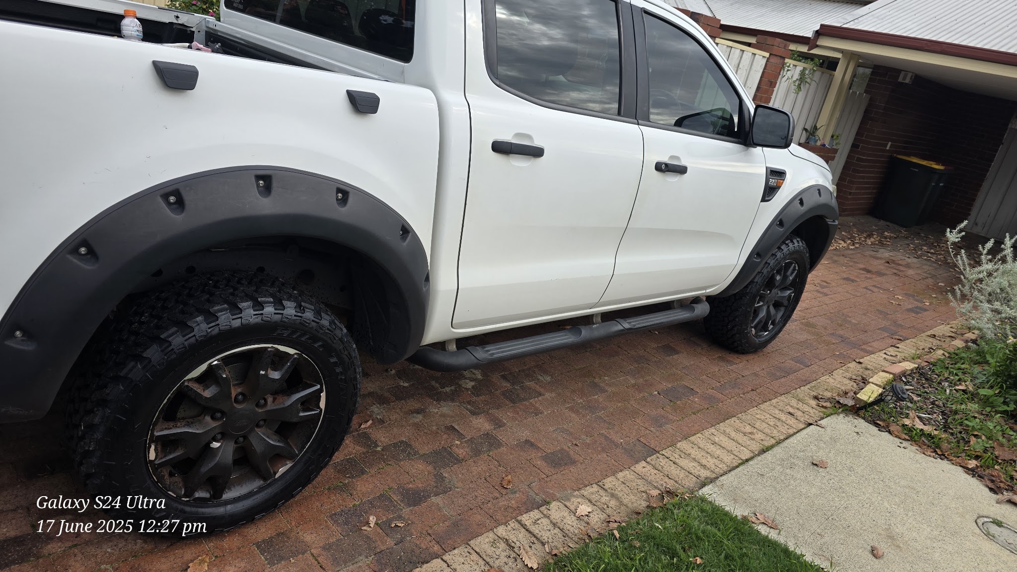 A white Ford Ranger with newly fitted off-road wheels and tyres on a brick driveway