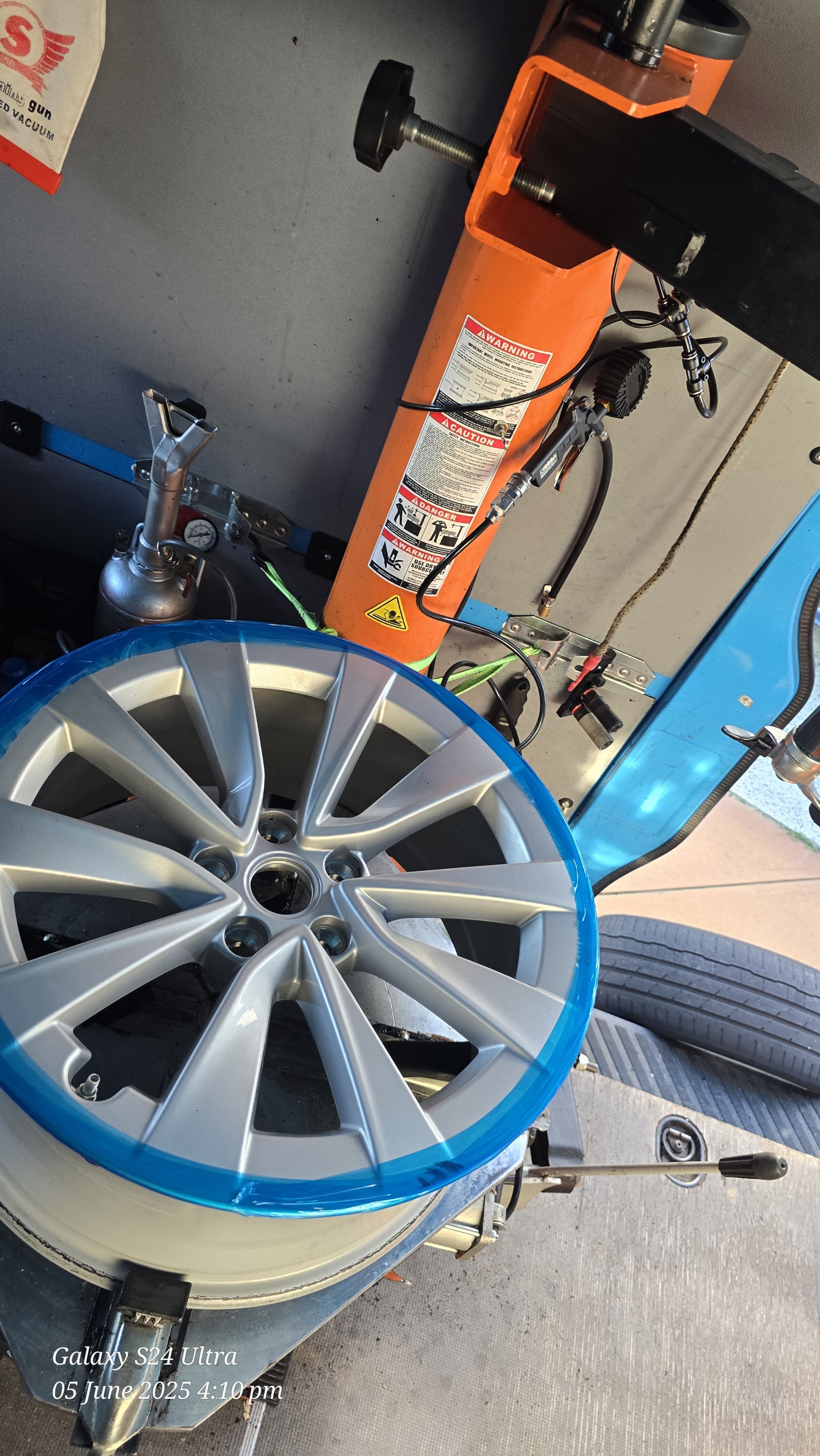 An alloy wheel on the tyre-changing machine inside the van